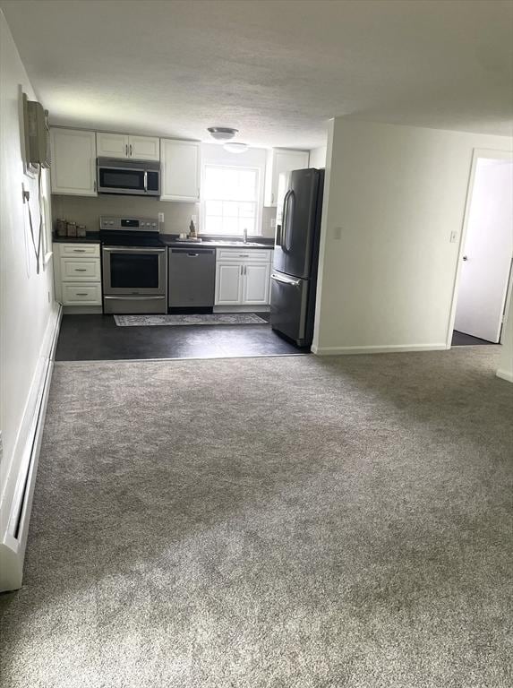 8 Zabriskie Unit 8B, Newburyport, MA 01950 - kitchen featuring stainless steel appliances, dark colored carpet, baseboards, and dark countertops