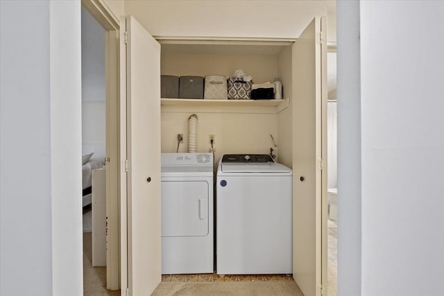 clothes washing area with washer and dryer and light carpet