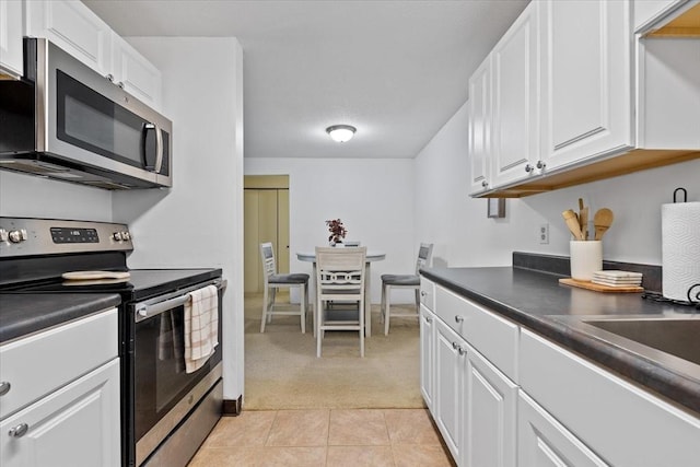 kitchen with white cabinets, appliances with stainless steel finishes, and light tile patterned floors