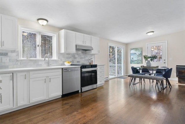 kitchen featuring appliances with stainless steel finishes, decorative backsplash, vaulted ceiling, white cabinets, and sink