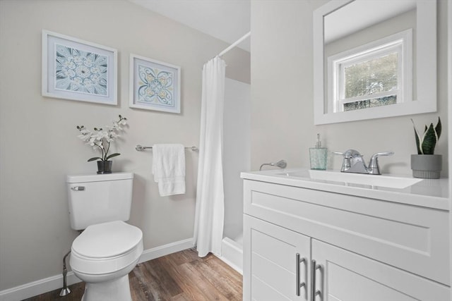 bathroom featuring toilet, a shower with shower curtain, hardwood / wood-style floors, and vanity