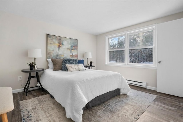 bedroom with baseboard heating and hardwood / wood-style floors