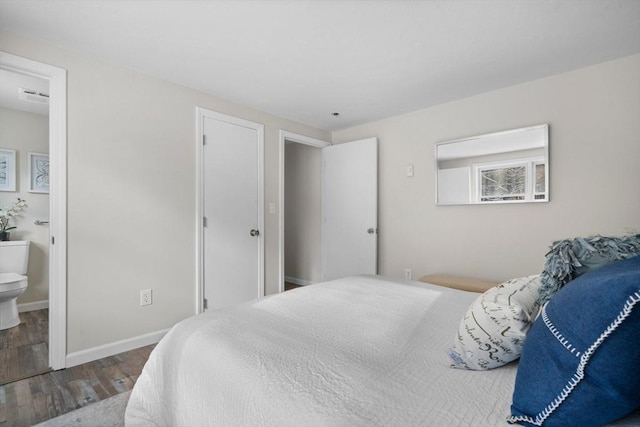 bedroom featuring ensuite bath and hardwood / wood-style floors