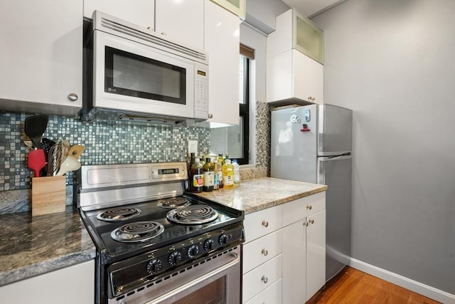12 Stoneholm Unit 621, Boston, MA 02115 - kitchen featuring electric range, white microwave, freestanding refrigerator, white cabinets, and backsplash