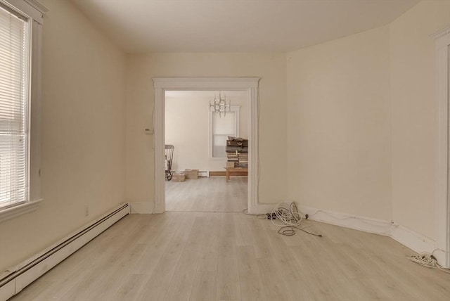 69 Metropolitan Ave, Boston, MA 02131 - unfurnished room with a baseboard heating unit, light wood-style floors, and a chandelier