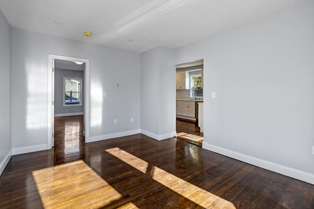 spare room with sink and dark hardwood / wood-style floors