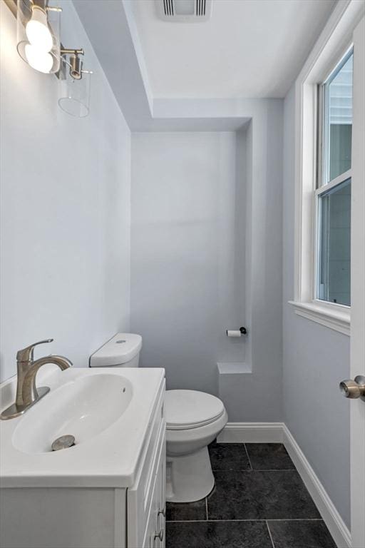 bathroom with toilet, tile patterned flooring, and vanity