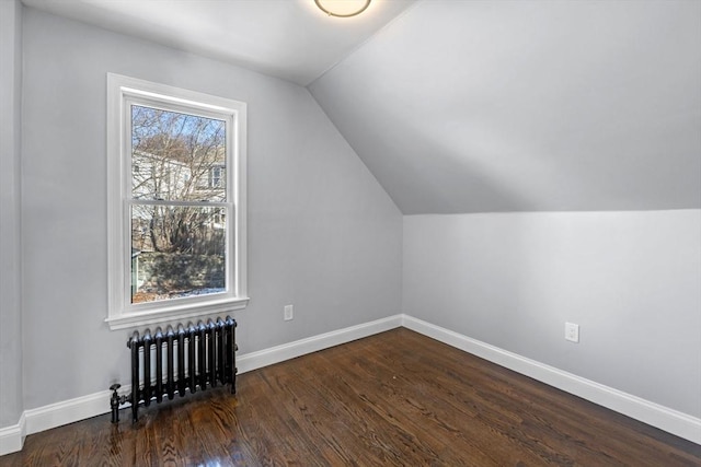 bonus room featuring dark hardwood / wood-style floors, vaulted ceiling, radiator, and plenty of natural light