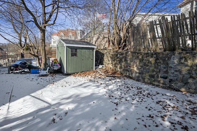 yard layered in snow featuring a shed