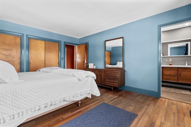 bedroom with dark wood-type flooring and ensuite bathroom