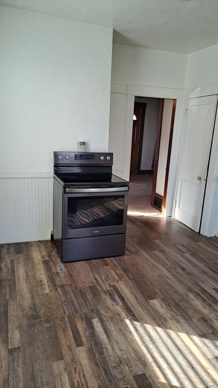 room details with wood-type flooring and electric stove