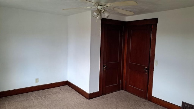 empty room with ceiling fan and light carpet