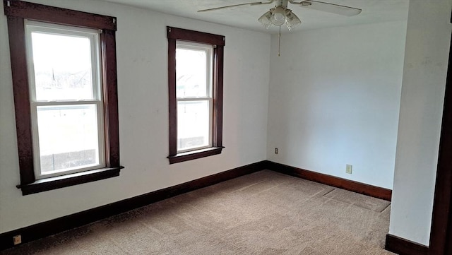 carpeted spare room featuring ceiling fan