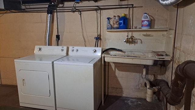 clothes washing area featuring washing machine and dryer and sink