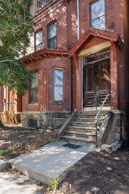 view of exterior entry with brick siding
