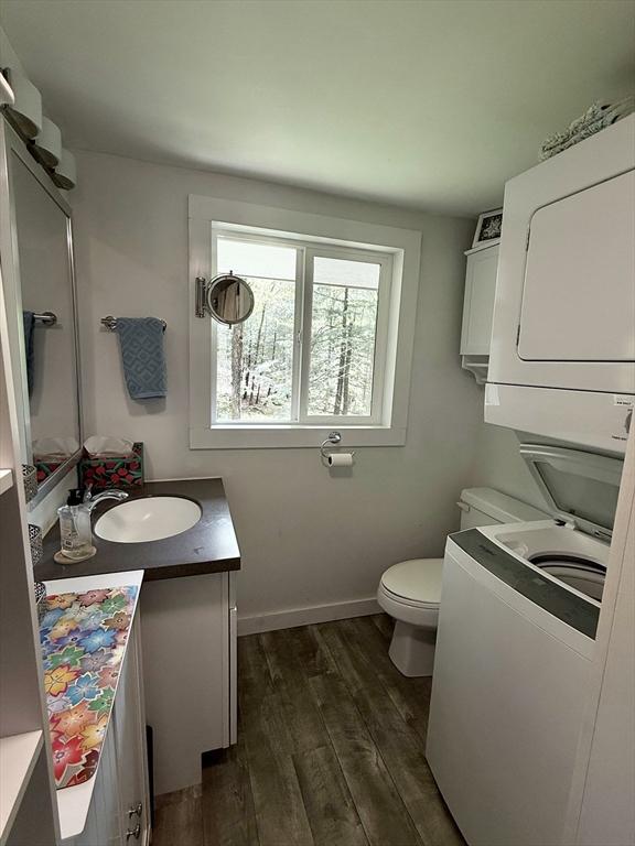 12 Cherry Rd, Goshen, MA 01032 - bathroom featuring stacked washing machine and dryer, toilet, vanity, wood finished floors, and baseboards