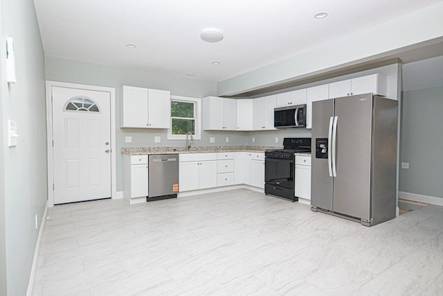 29 Roanoke St, Lynn, MA 01904 - kitchen featuring stainless steel appliances, white cabinets, baseboards, a sink, and light stone counters