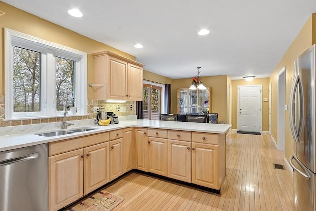 93 Towne Hill Rd, Haverhill, MA 01835 - kitchen with appliances with stainless steel finishes, light brown cabinetry, a peninsula, a sink, and light countertops