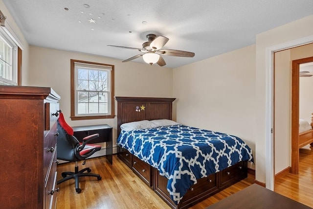 bedroom featuring a ceiling fan, baseboards, and wood finished floors