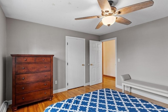 bedroom featuring light wood-type flooring, baseboards, a baseboard heating unit, and a ceiling fan