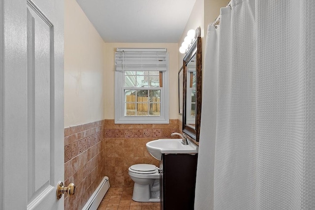 full bathroom with vanity, a wainscoted wall, tile walls, toilet, and baseboard heating