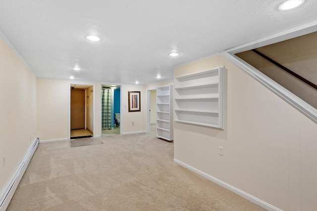 finished basement with light colored carpet, baseboards, baseboard heating, and a textured ceiling