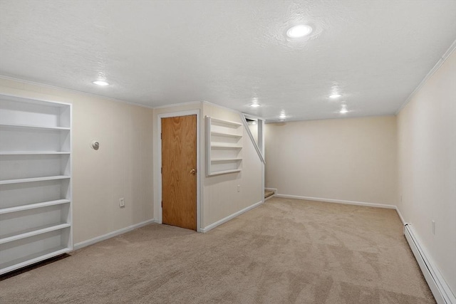 finished below grade area with baseboard heating, carpet flooring, a textured ceiling, and built in features