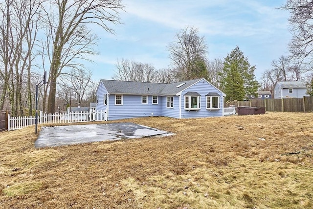 back of property featuring a patio, a yard, and a fenced backyard