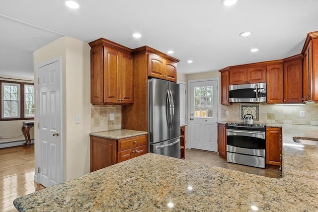 kitchen featuring decorative backsplash, light stone counters, recessed lighting, and appliances with stainless steel finishes