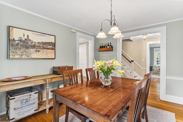 571 Washington St, Winchester, MA 01890 - dining area with a chandelier, wood finished floors, stairway, crown molding, and baseboards
