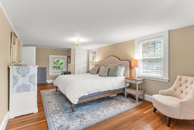 571 Washington St, Winchester, MA 01890 - bedroom with radiator heating unit, baseboards, and light wood finished floors