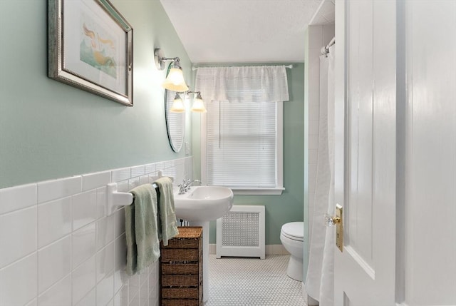 571 Washington St, Winchester, MA 01890 - full bathroom featuring radiator, toilet, tile patterned flooring, and tile walls