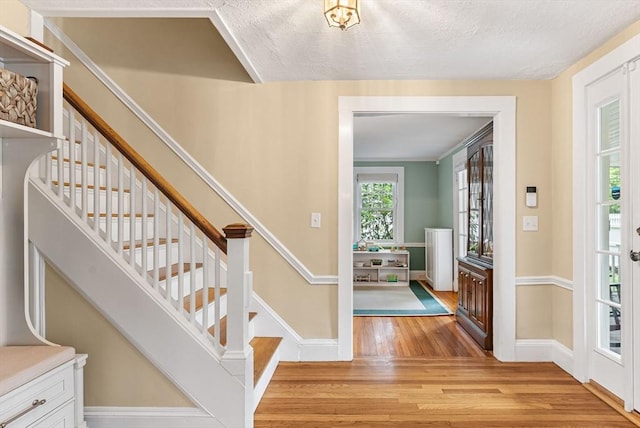 571 Washington St, Winchester, MA 01890 - foyer entrance featuring light wood-type flooring, stairs, baseboards, and a textured ceiling
