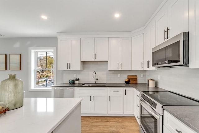 1000 Washington St Unit 213, Dedham, MA 02026 - kitchen with stainless steel appliances, a sink, white cabinetry, and recessed lighting