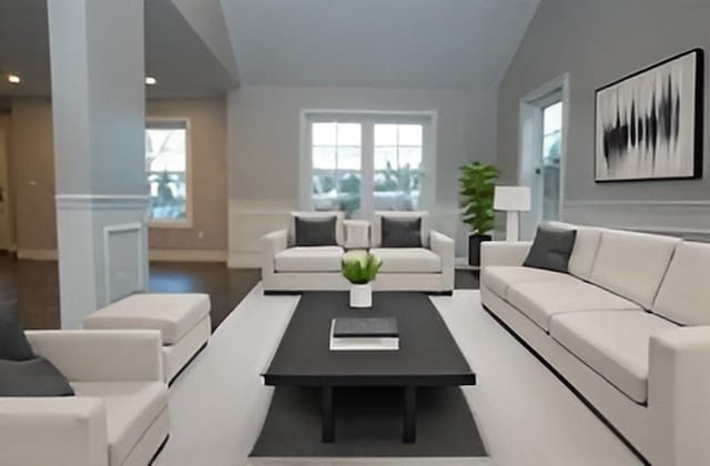 living room featuring a wainscoted wall, lofted ceiling, and recessed lighting