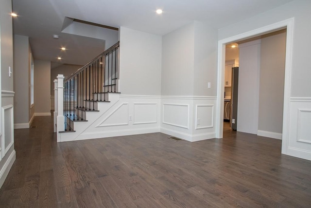 unfurnished room featuring stairway, recessed lighting, dark wood-style flooring, visible vents, and a decorative wall