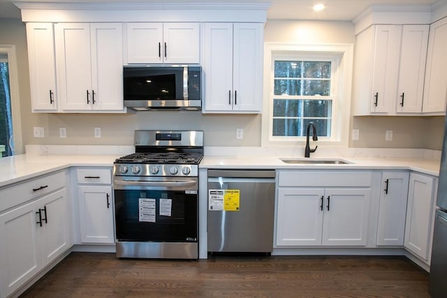 kitchen featuring white cabinetry, recessed lighting, dark wood-style flooring, stainless steel appliances, and a sink