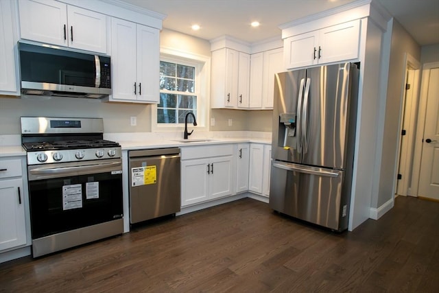 kitchen featuring light countertops, dark wood-type flooring, a sink, white cabinets, and appliances with stainless steel finishes