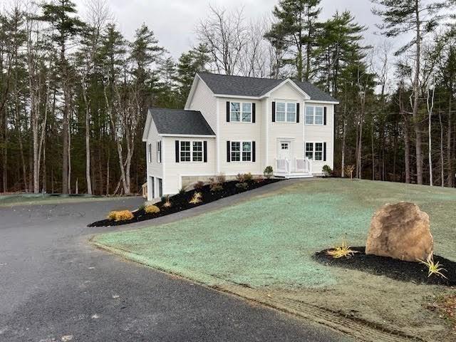colonial home with a garage and aphalt driveway