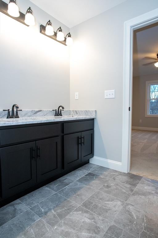 bathroom with baseboards, ceiling fan, and a sink