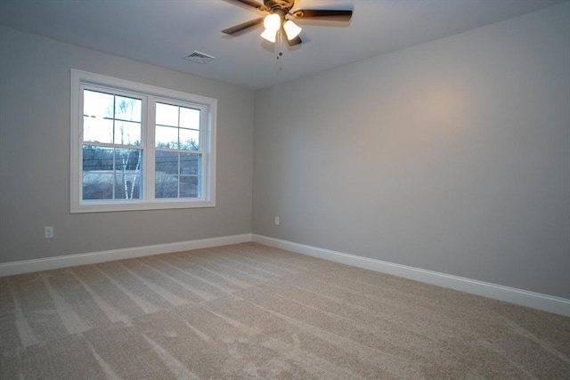 empty room with light carpet, baseboards, visible vents, and a ceiling fan