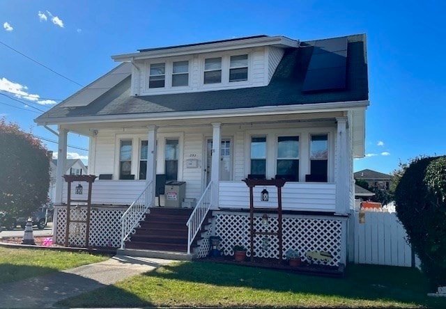 view of front of house featuring covered porch and a front lawn