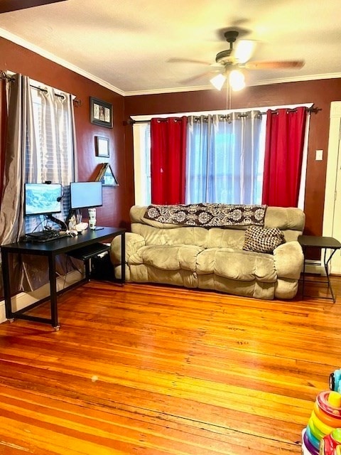 living room featuring a healthy amount of sunlight, hardwood / wood-style flooring, ceiling fan, and crown molding