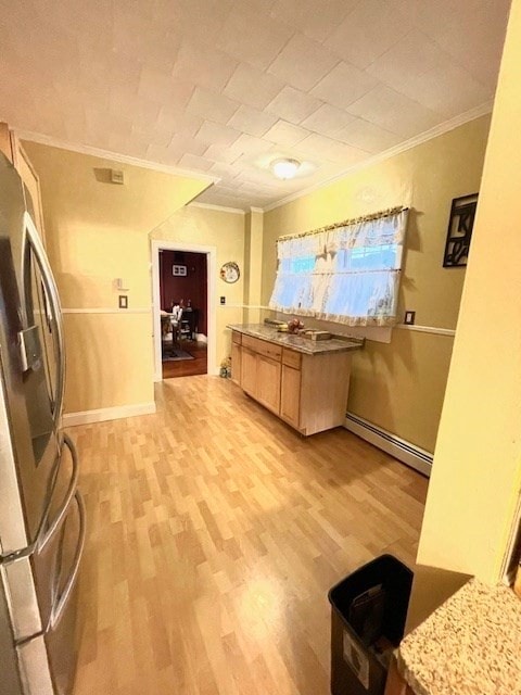 kitchen with a baseboard radiator, crown molding, stainless steel refrigerator, light brown cabinets, and light hardwood / wood-style flooring