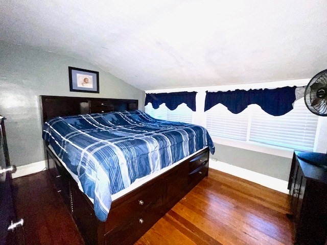 bedroom featuring dark wood-type flooring and lofted ceiling