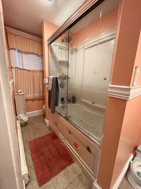 bathroom with toilet and combined bath / shower with glass door