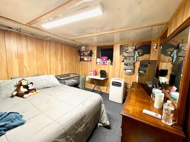 carpeted bedroom featuring wooden walls