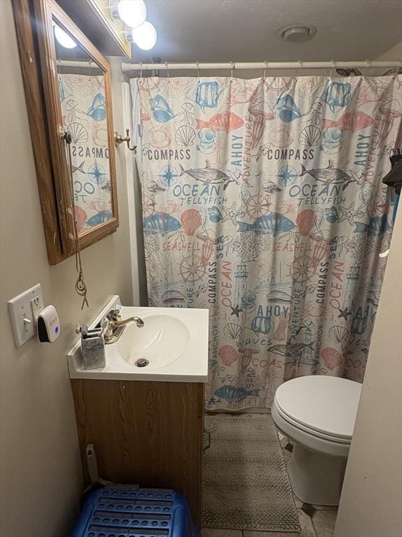 bathroom with tile patterned floors, vanity, curtained shower, and toilet