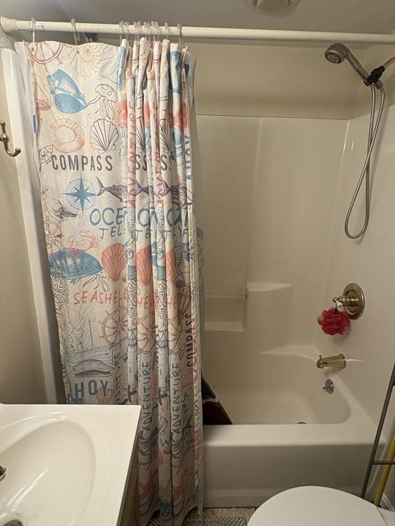 full bathroom with shower / bath combo, toilet, and sink