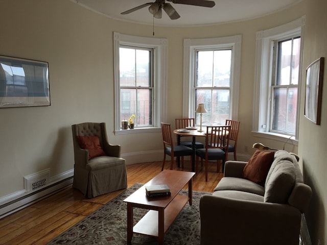 living room featuring ceiling fan, light hardwood / wood-style floors, and crown molding